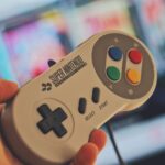 person holding white snes controller